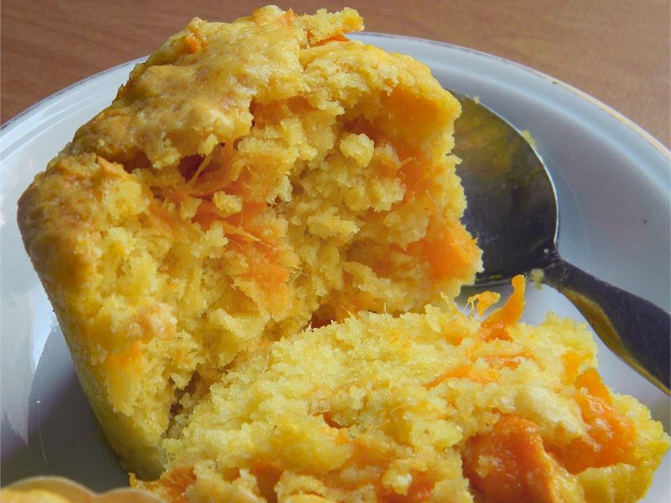 Close up view of a Fresh Mango Muffin on a plate with a spoon