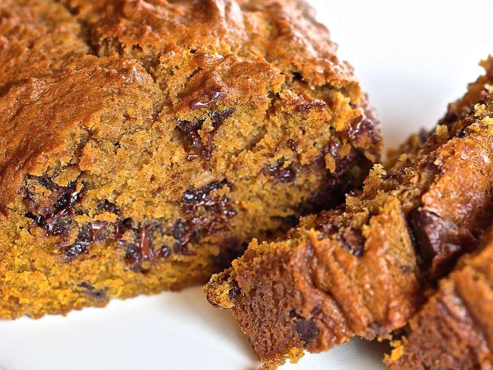 Close up view of sliced Pumpkin Chocolate Chip Bread on a white platter