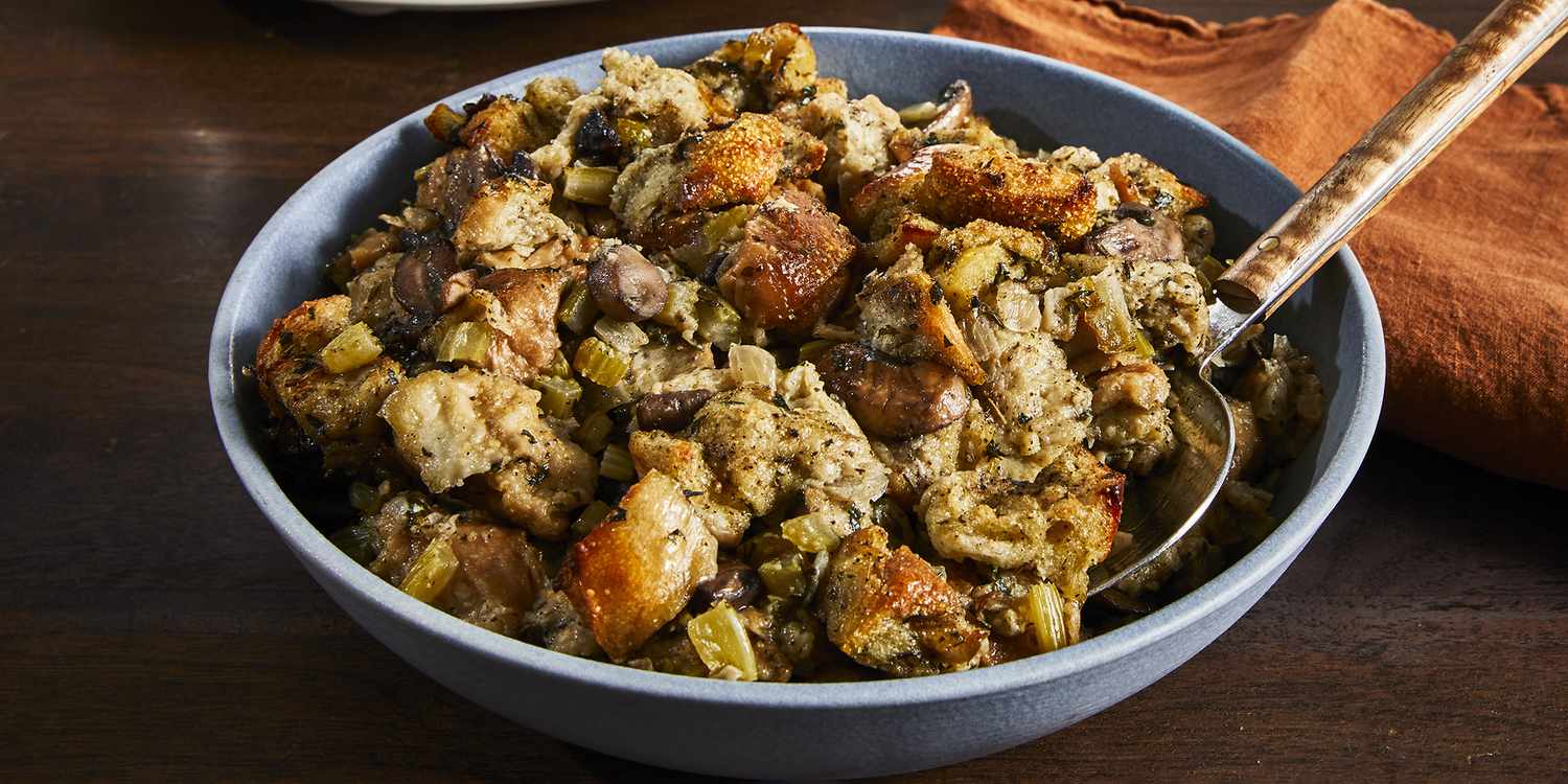 A close up view on a bowl of slow-cooker stuffing with the slow cooker in the background