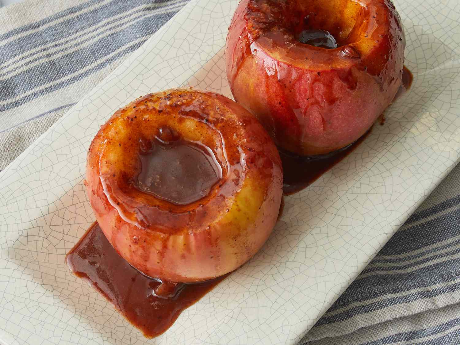 Looking at two microwave baked apples on a plate.