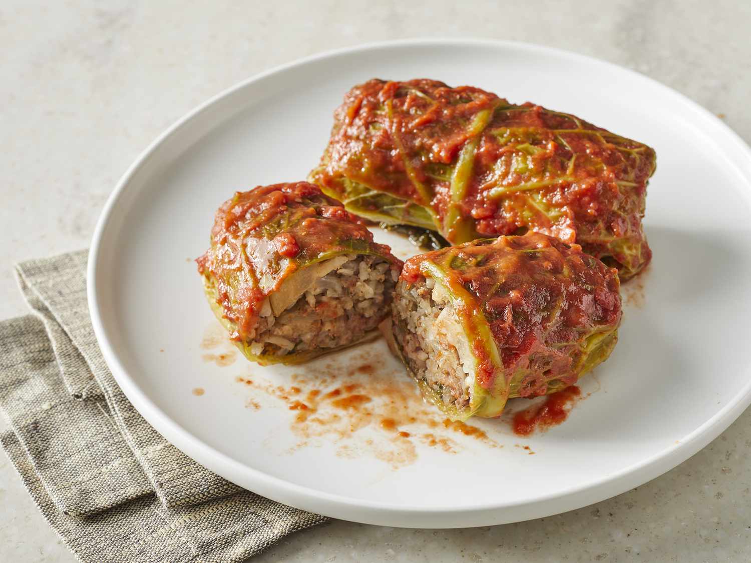 High angle looking at a plate of cabbage rolls with one cut in half