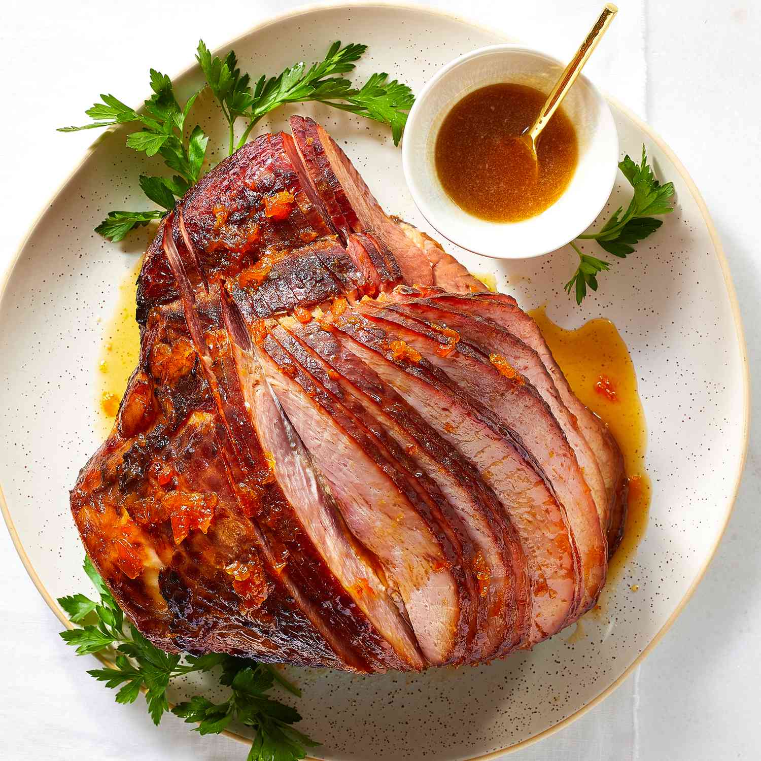 Looking down at a apricot brown sugar ham, sliced and served on a plate
