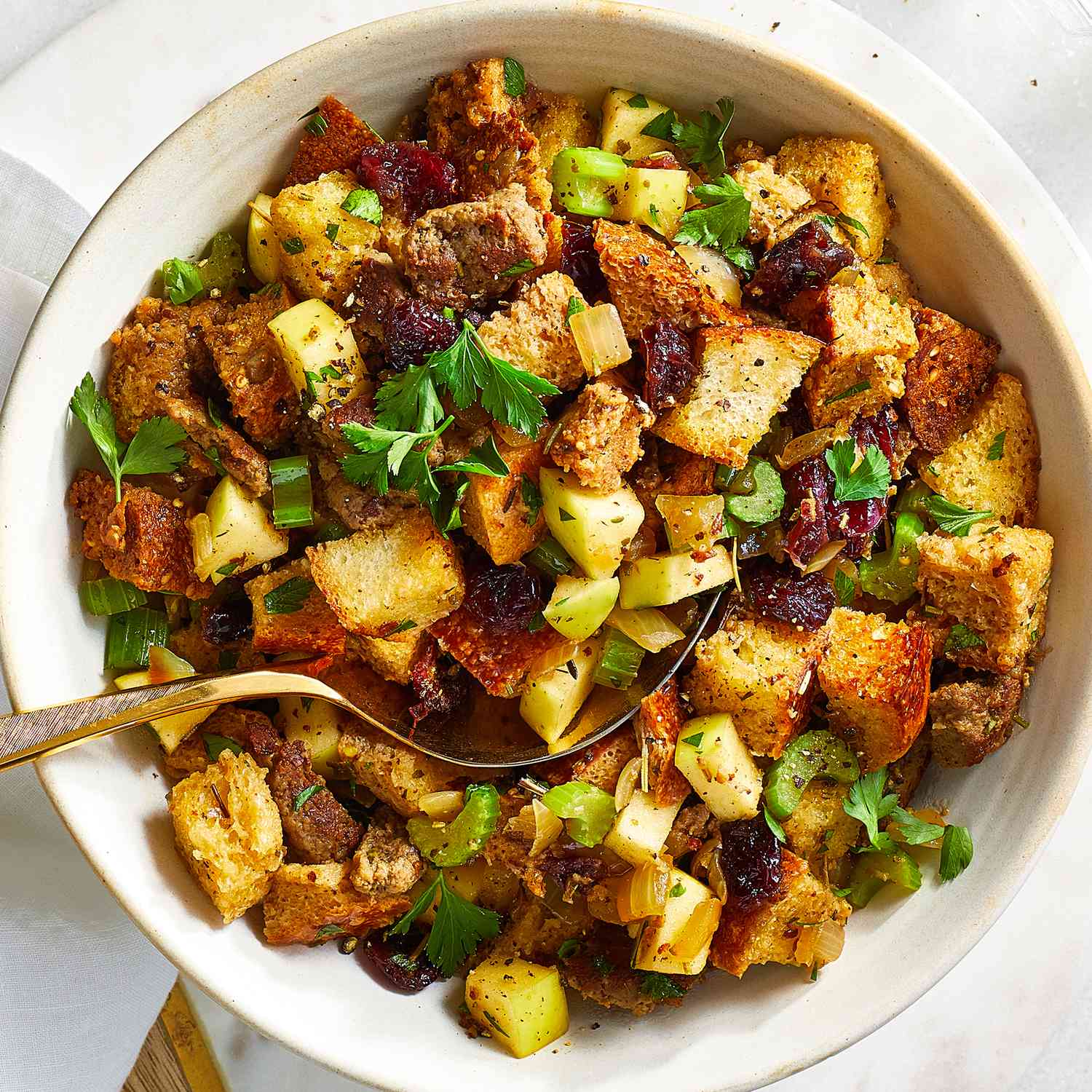 Looking down at a large bowl of sausage, apple and cranberry stuffing