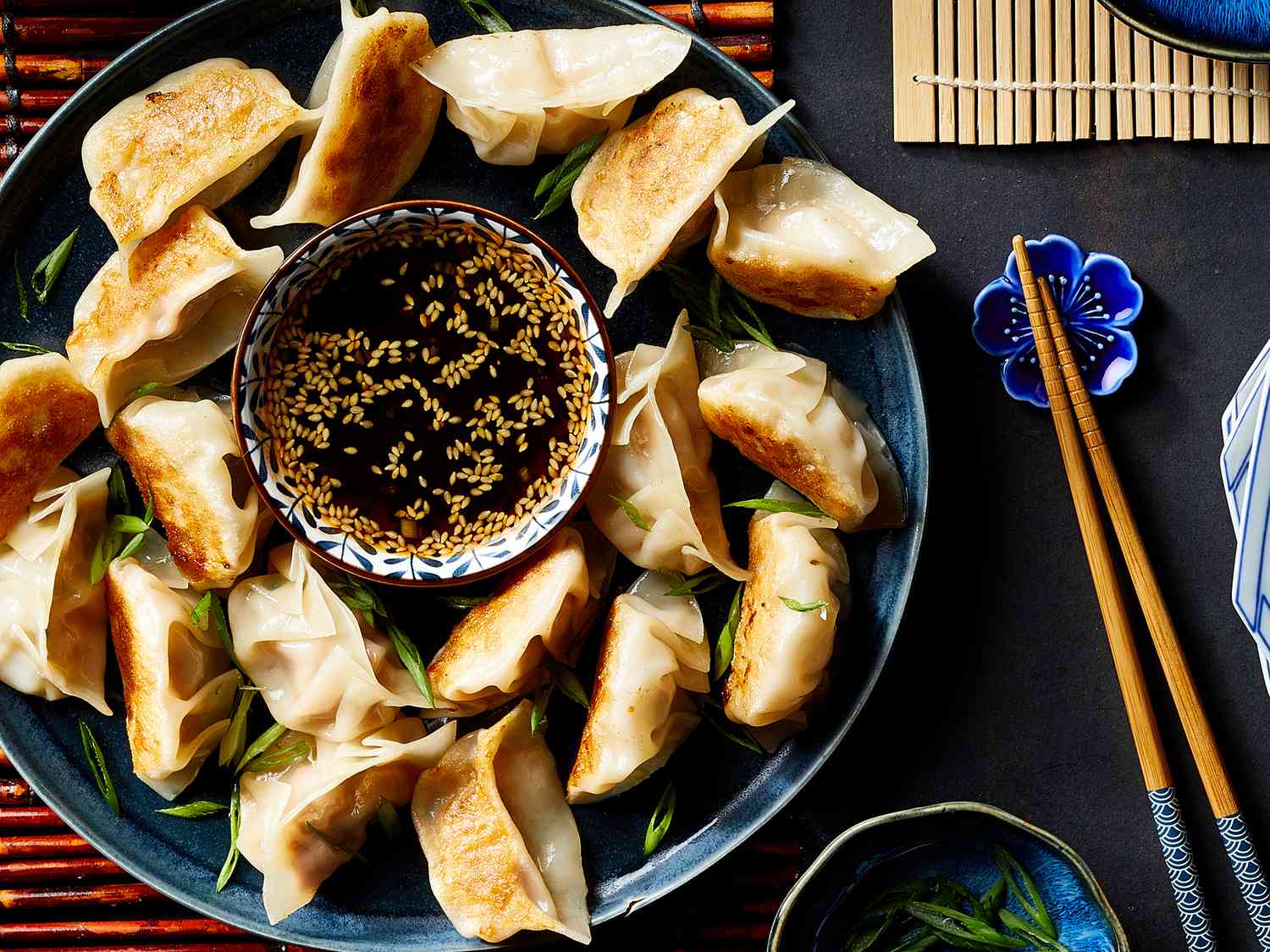 An overhead view of Chinese pork dumplings served with a dipping sauce.