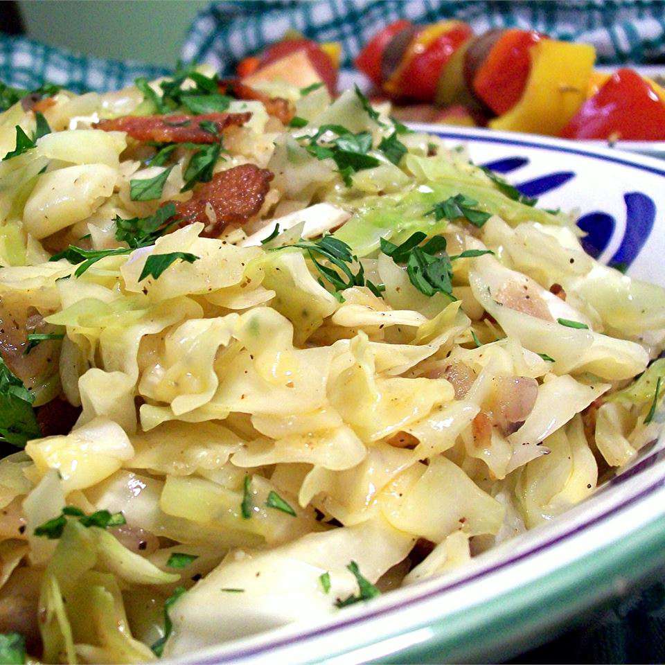 Fried Cabbage with Bacon, Onion, and Garlic on a white, green, and blue plate