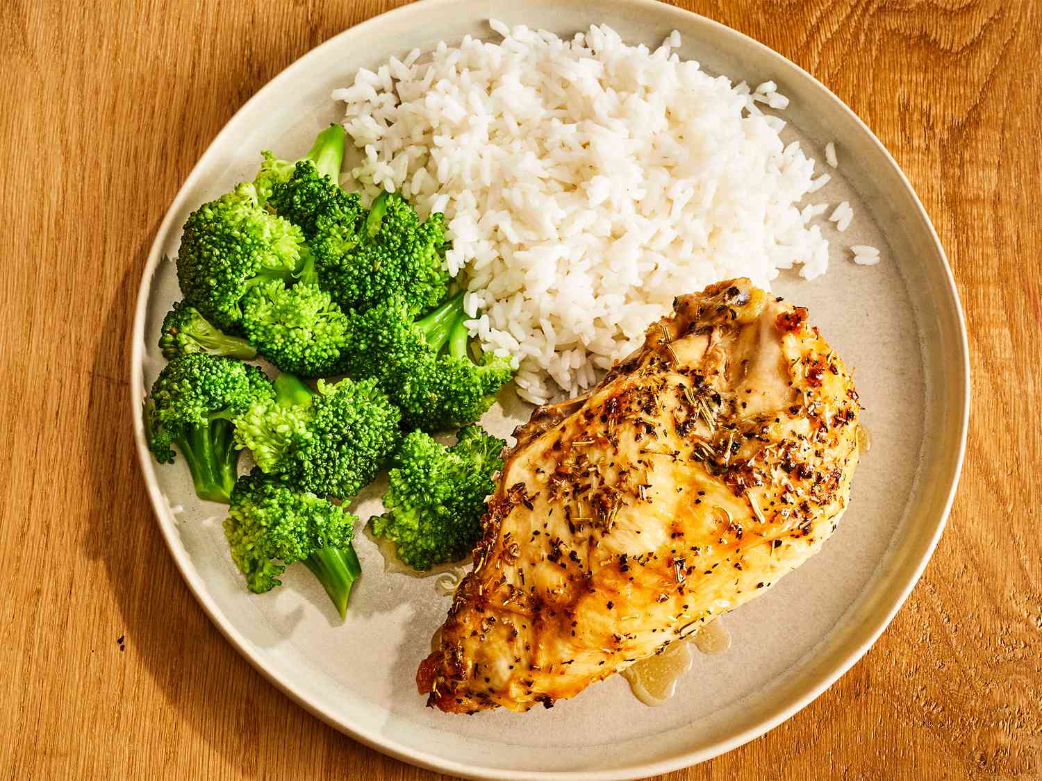 Completed baked split chicken breast with broccoli and rice on the side.