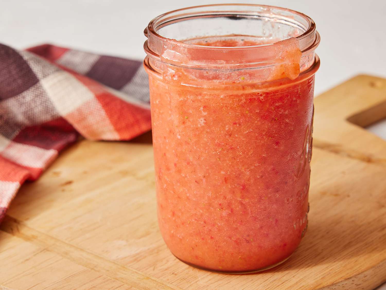 Side angle view of a fruit smoothie in a jelly jar glass