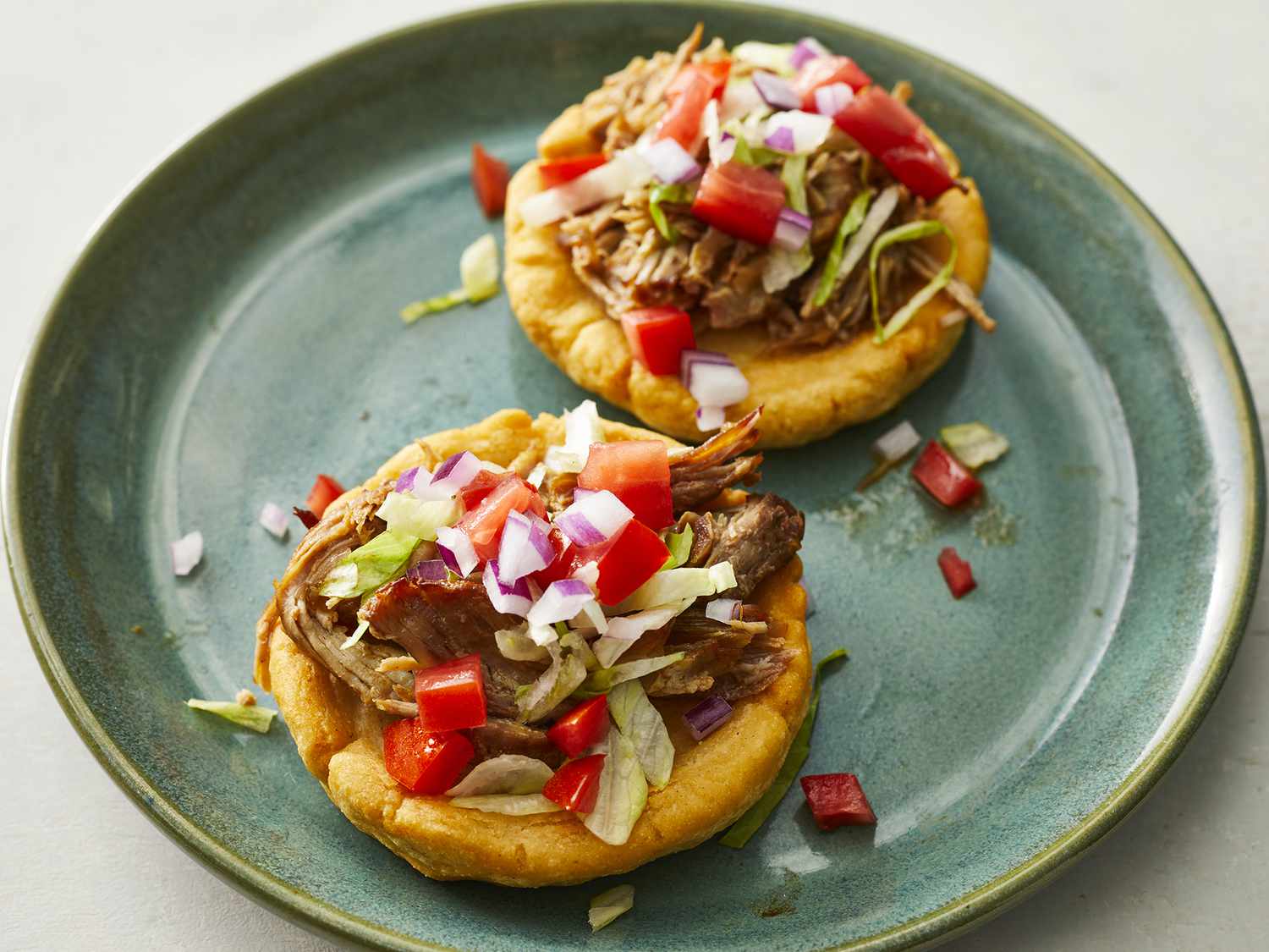 High angle looking at two Mexican Sopes on a plate