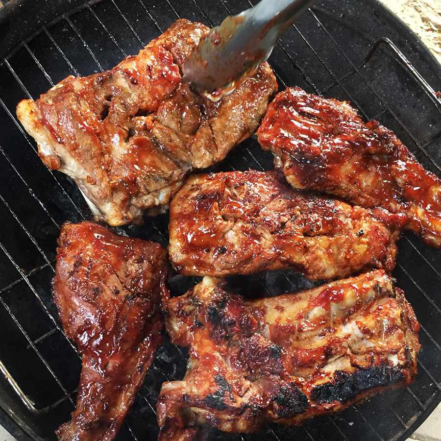 Close up view of Barbecue Ribs on a grill and Barbecue Ribs held above the grill with tongs