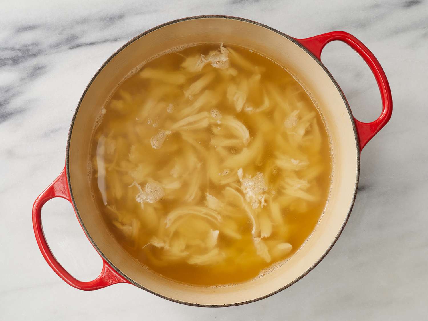 Chicken, broth and water combined in a large pot, boiling over medium heat. 