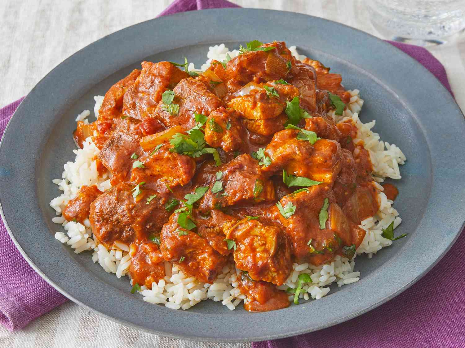 Overhead view on a plate of rice topped with chicken tikka masala