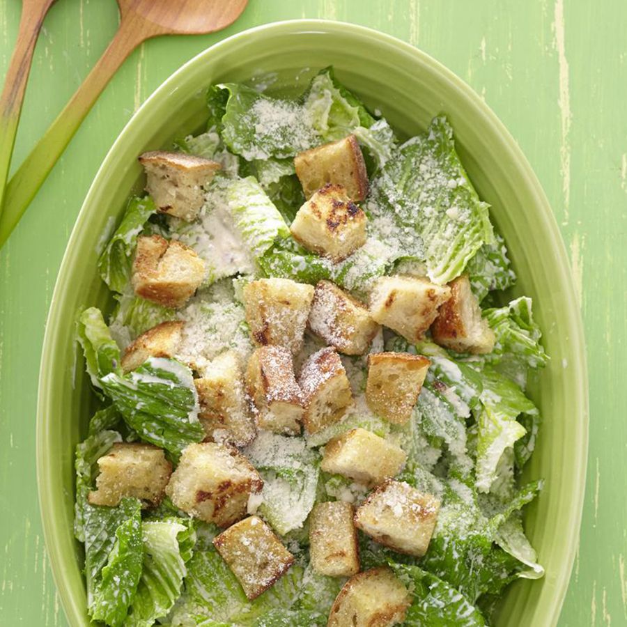 Overhead view of Ceasar salad on a green serving platter