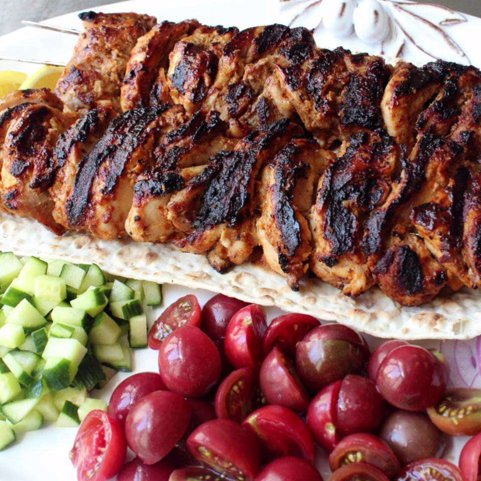 Close up view of Turkish Chicken Kebabs, tomatoes and cucumbers on a platter