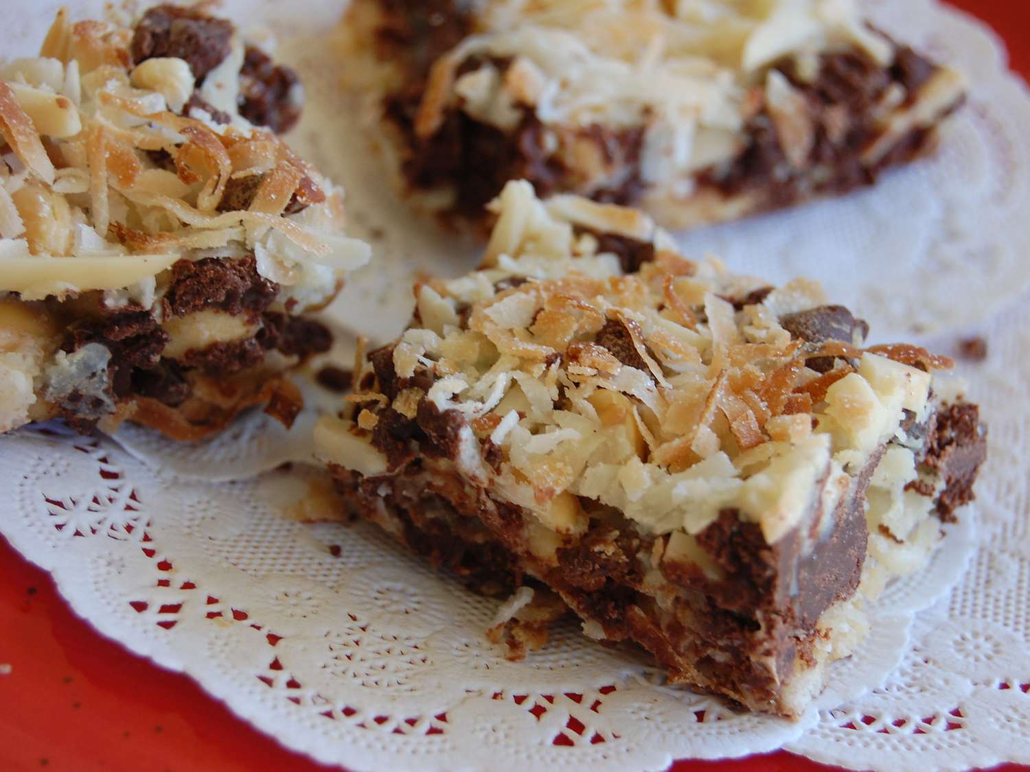 Close up view of Gluten-Free Layer Bars garnished with toasted coconut on a plate
