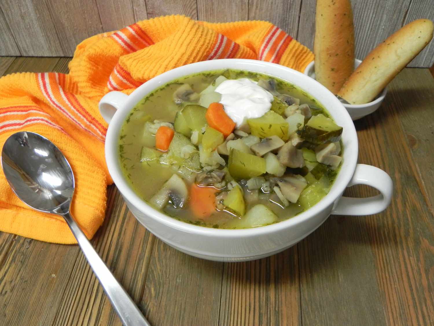 Russian-barley-and-pickle-soup in bowl with bread and orange napkin