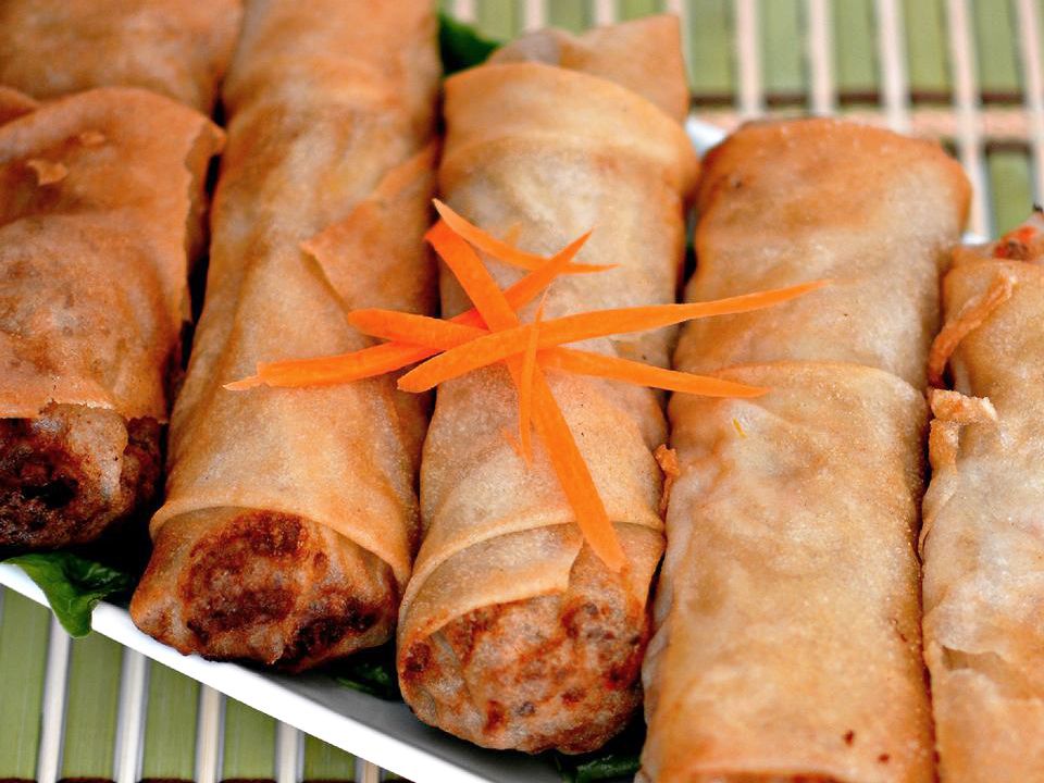 Close up view of Authentic Vietnamese Spring Rolls garnished with carrots on a plate