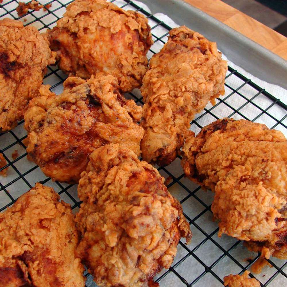 Close up view of fried chicken on a cooling rack