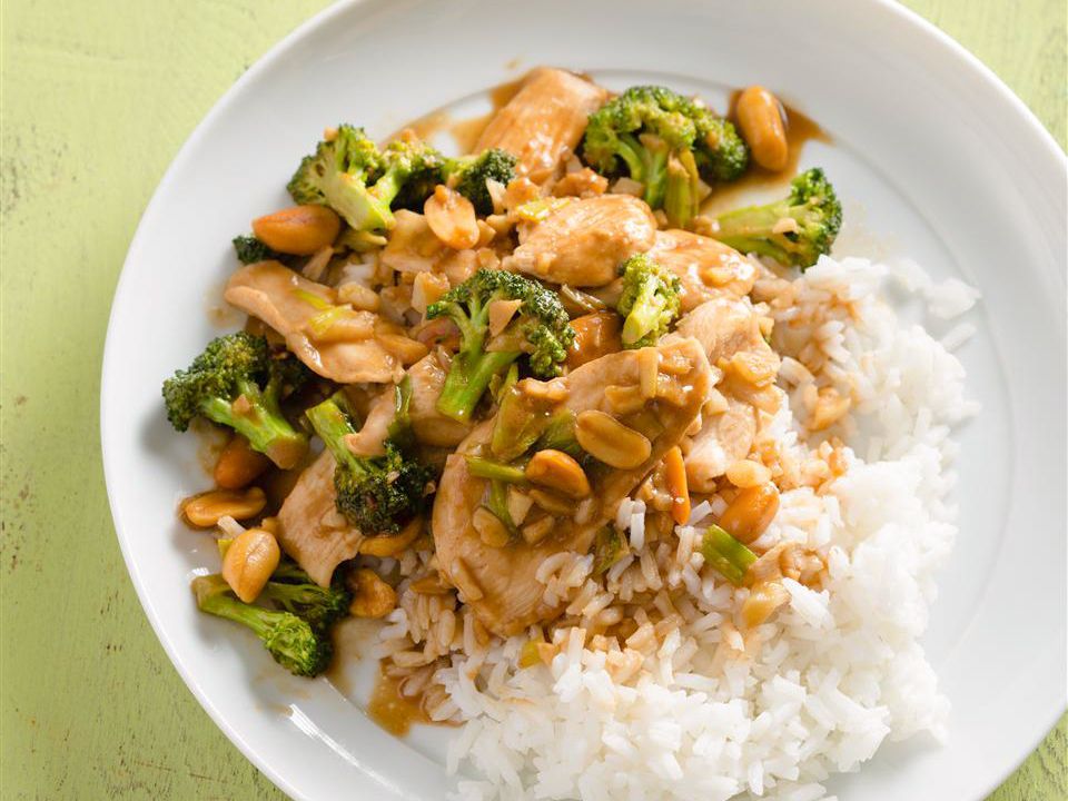 Close up view of Thai Peanut Chicken served with white rice on a white plate