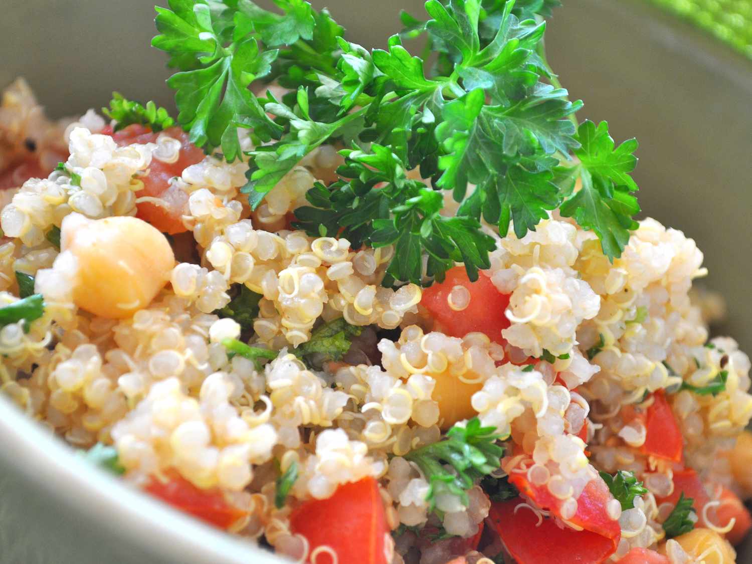 Close up view of Quinoa with Chickpeas and Tomatoes garnished with fresh herbs in a bowl