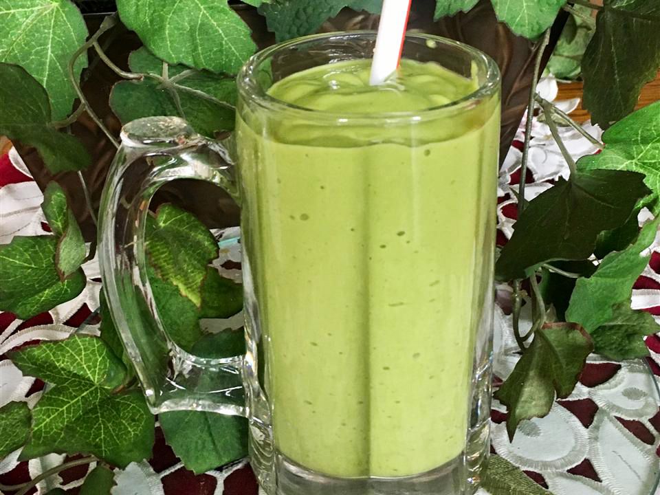 Close up view of a Banana, Avocado, and Spinach Smoothie in a glass mug with a straw