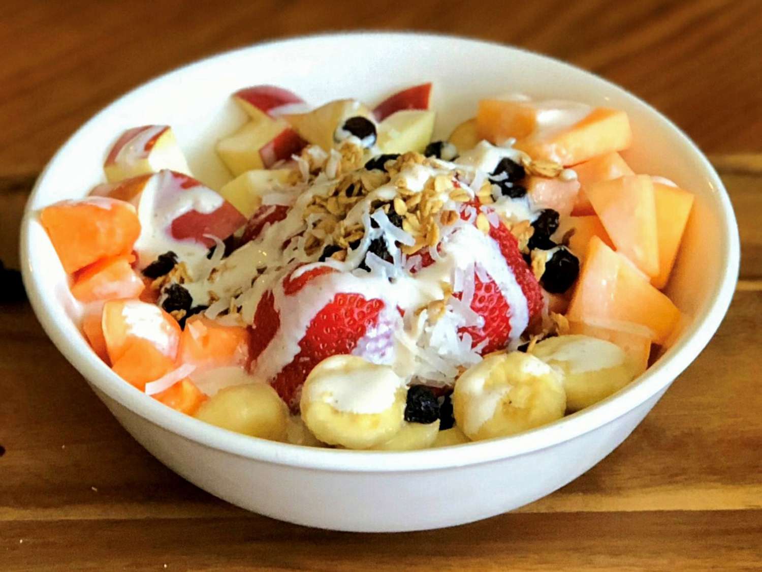 Close up view of a Mexican Fruit Bowl garnished with shaved coconut and raisins in a bowl