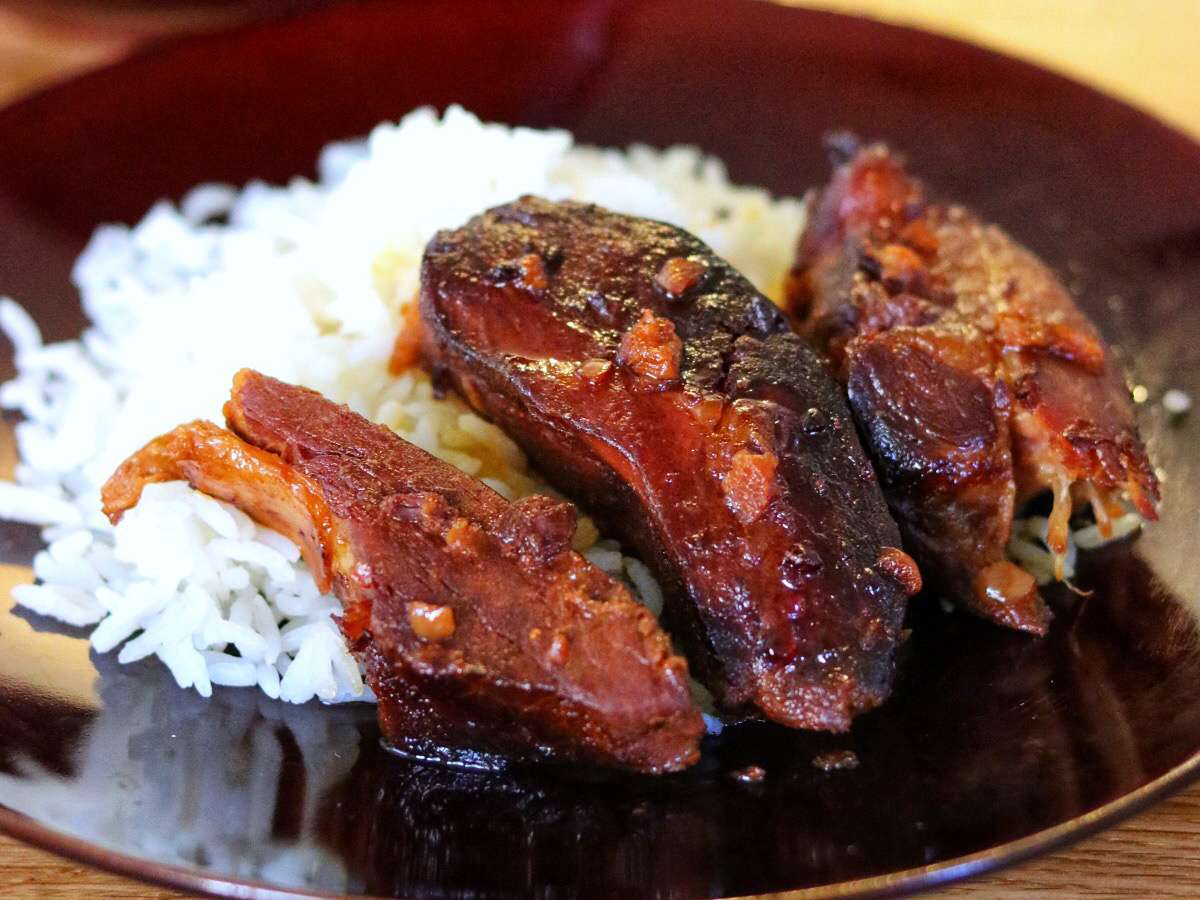 Close up view of Country Ribs over white rice on a plate