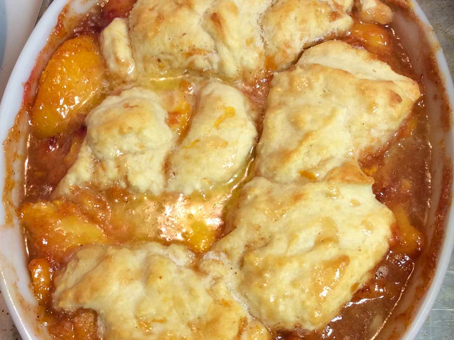 Close up view of Fresh Peach Cobbler in a white baking dish