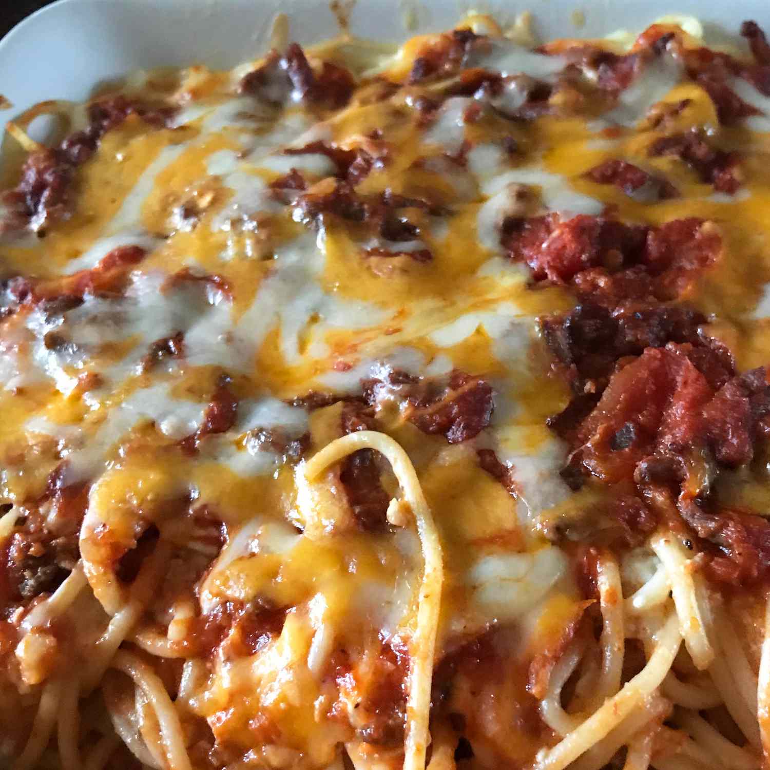 Close up view of baked spaghetti with melted cheese on top