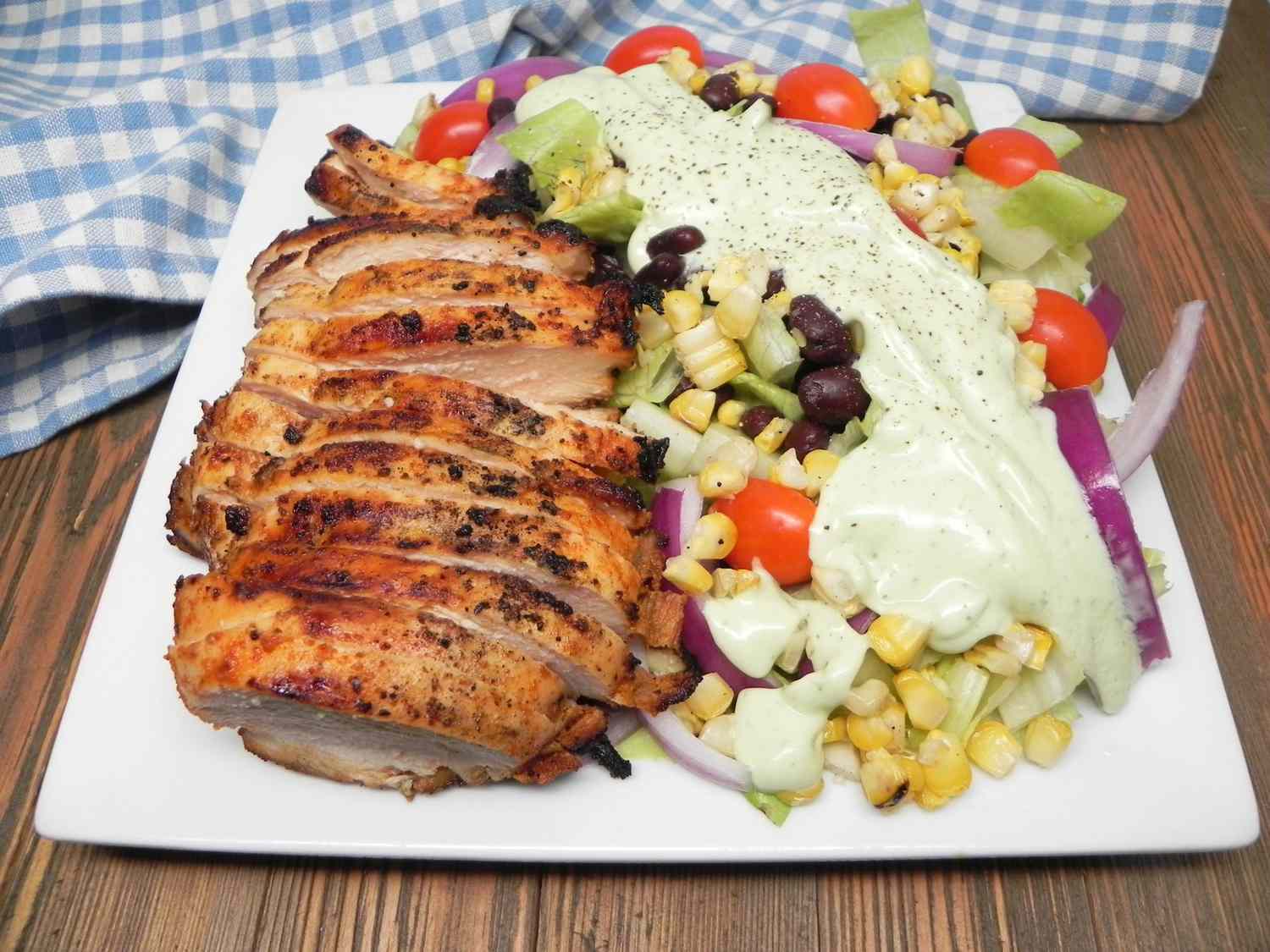 Sliced grilled chicken on southwest salad with avocado ranch dressing