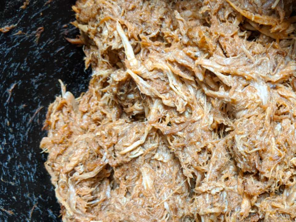 Close up view of Slow-Cooker Pulled Pork in a pan