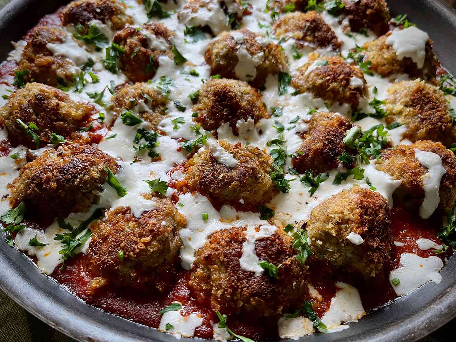 Skillet with meatballs and melted mozzarella in marinara sauce