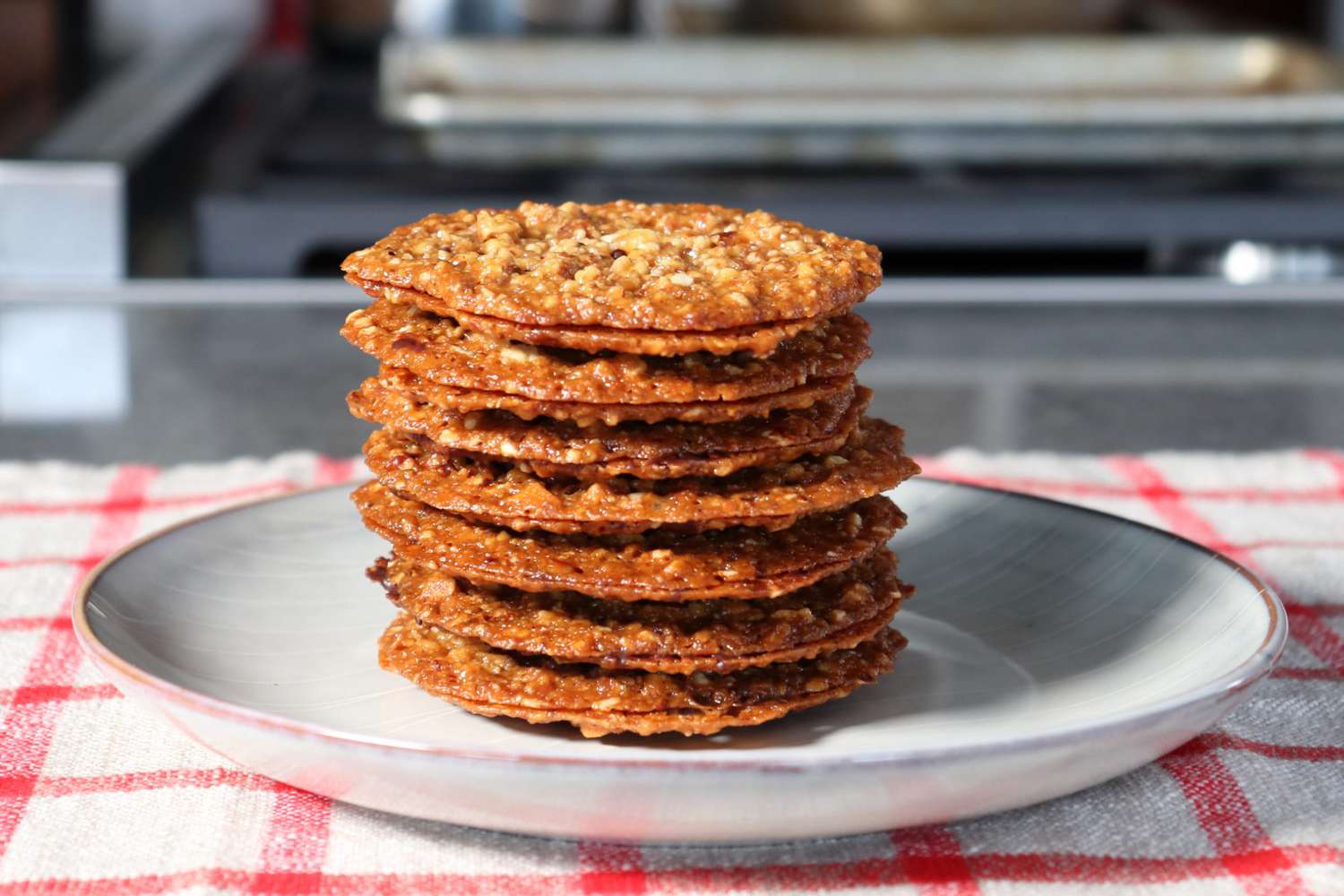 A stack of thin caramel-colored almond cookies