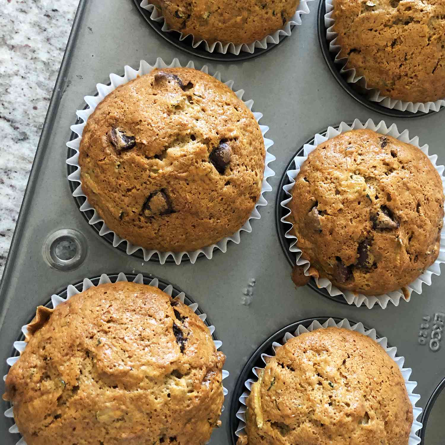 Close up view of Zucchini-Chocolate Chip Muffins in muffin tins