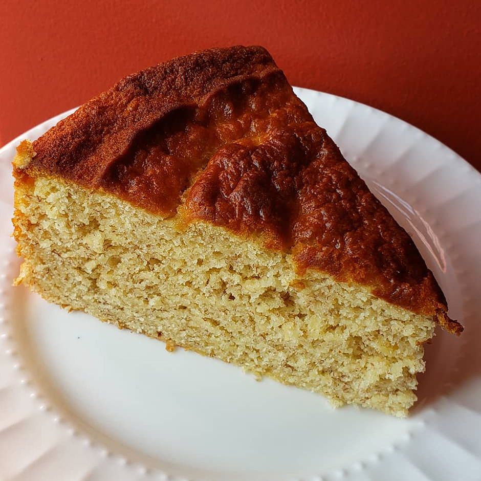 Close up view of a slice of banana cake on a white plate