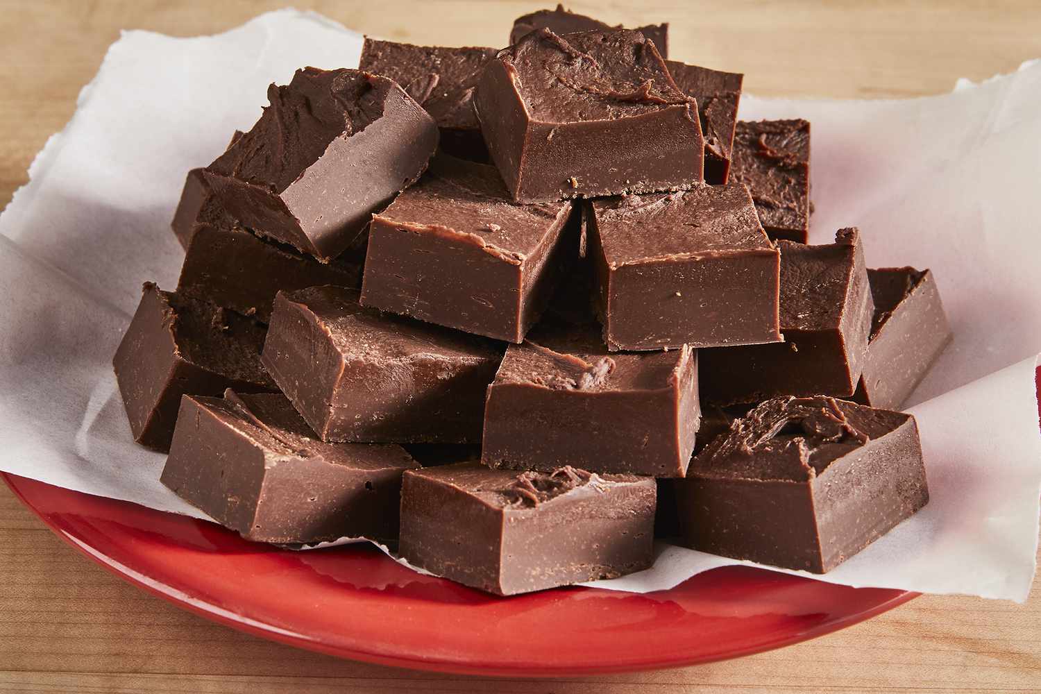 A low angle view of a big pile of chocolate fudge on a red plate